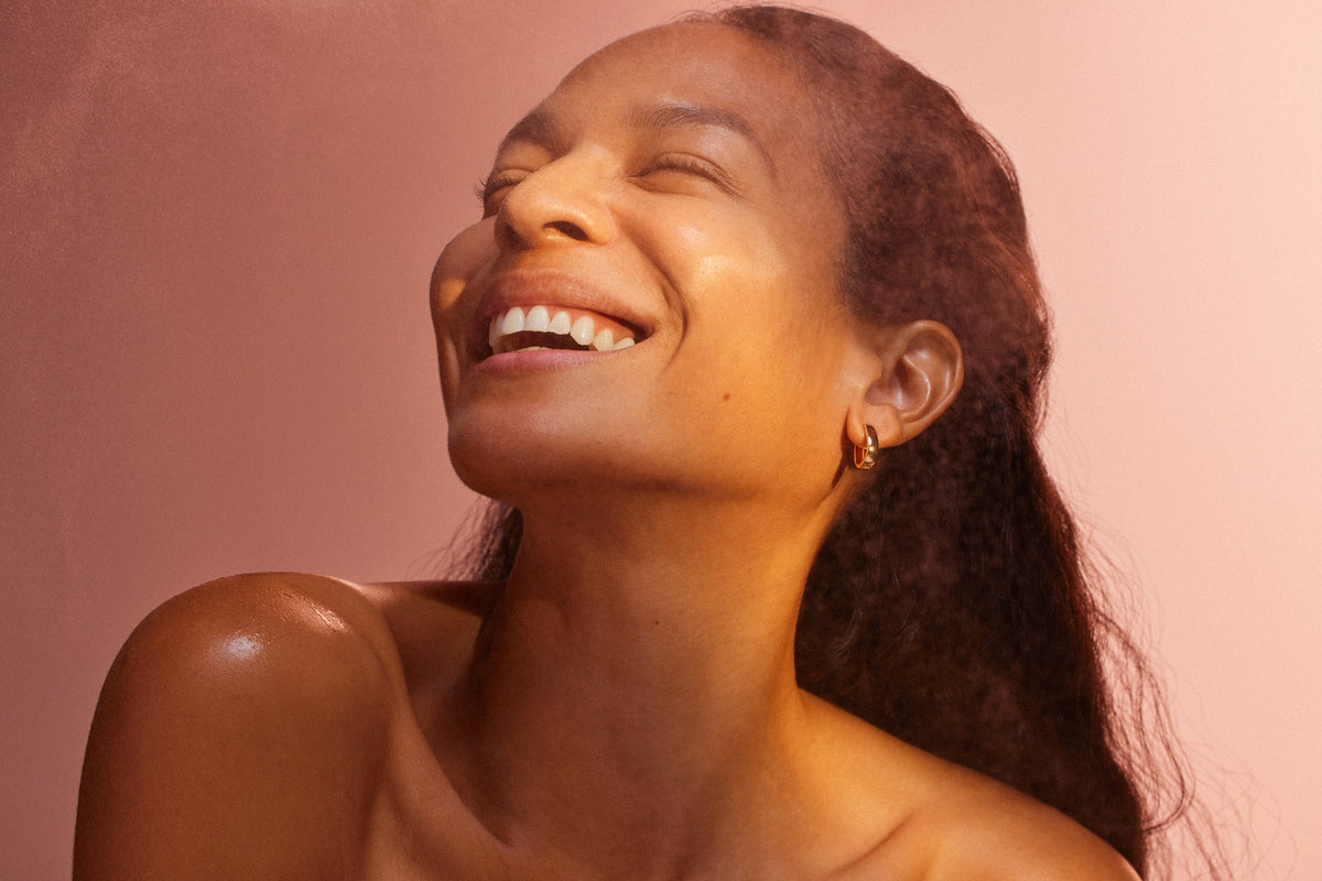 An image of a woman who is smiling after using red light therapy on her face