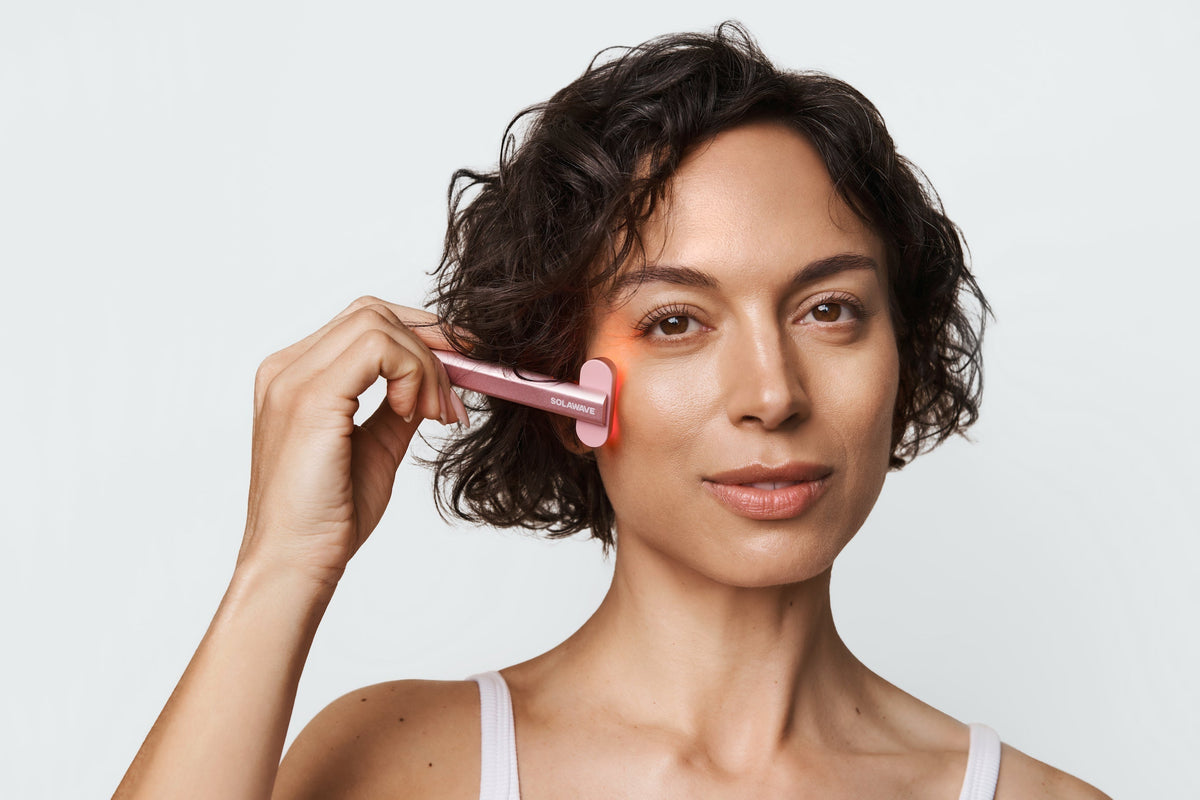 An image of a woman using red light on her face