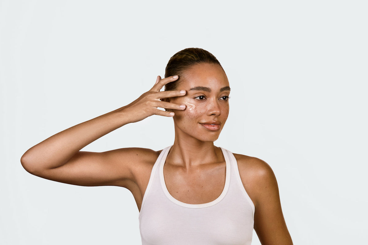 An image of a woman applying castor oil to her skin