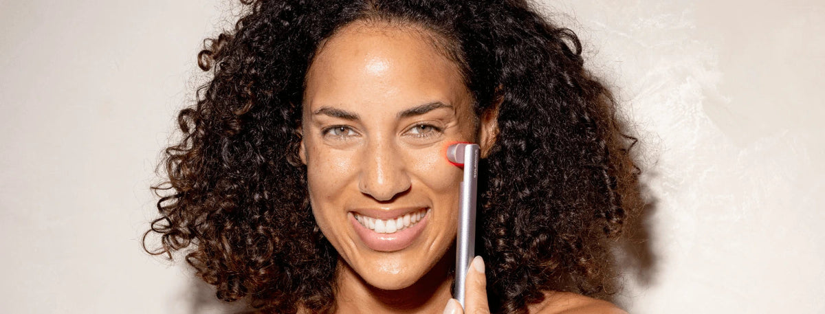 woman using rose gold skincare wand on face