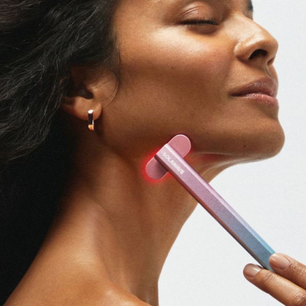 An image of a woman using red light therapy for scars