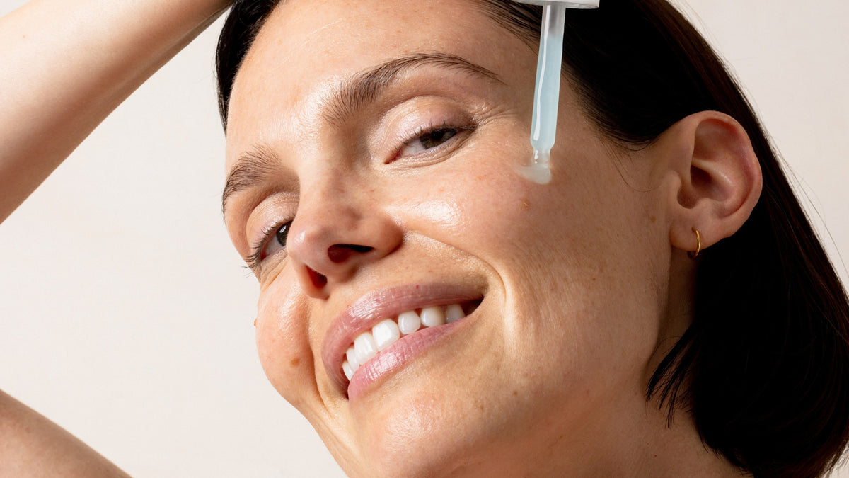 An image of a woman applying Solawave serum to her face