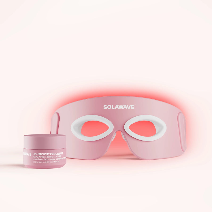 The Eye Recovery Pro Kit includes a rose LED face mask with SolaWave branding and an anti-aging eye mask design, along with a jar of LightBoost Eye Cream. Featuring LightBoost technology, the mask has eye cutouts and white details against a soft pink gradient. || Rose