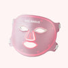 Pink LED face mask with glowing red light therapy panels across forehead, nose bridge, and mouth area.